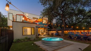 Uma casa moderna com piscina, área de estar externa e luzes de Natal.