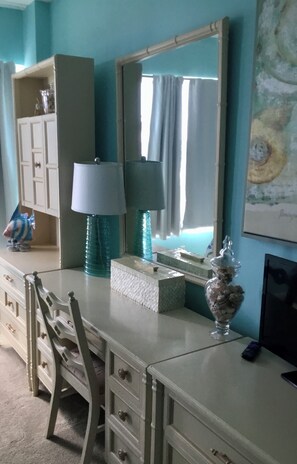 A room with a dresser, a mirror, a lamp, a vase, and a painting on the wall. - 2-bedroom condo in awesome Fort Lauderdale with AC and gym access (Fort Lauderdale)
