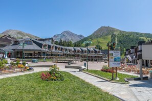 Un hotel con patio, mobiliario exterior y vistas a la montaña.