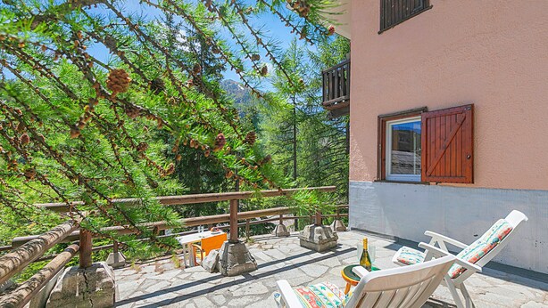 A patio with stone flooring, a wooden fence, and a table with chairs. - Appartamento La Radura (Claviere)