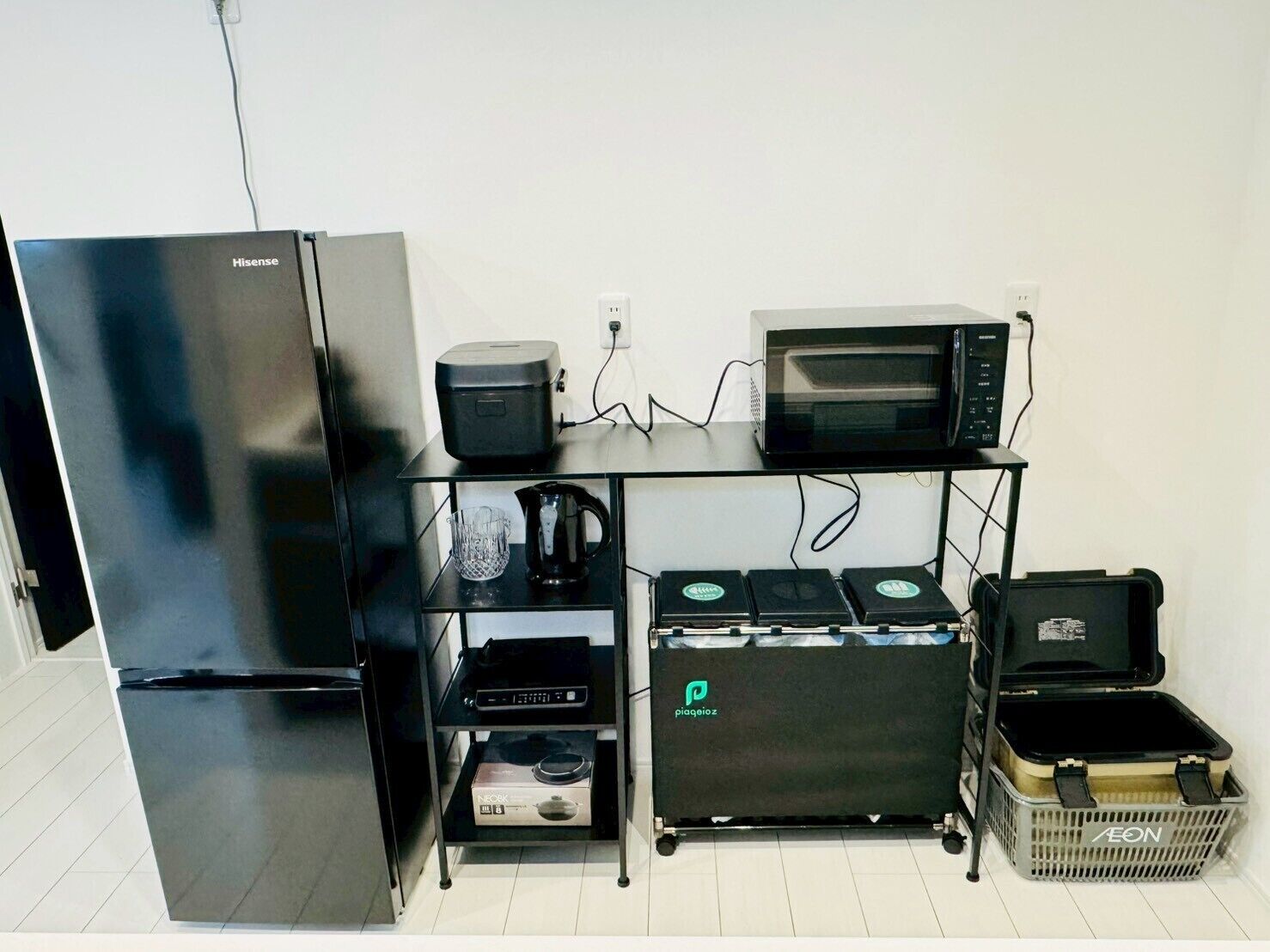 Una kitchenette compacta equipada con un refrigerador Hisense, un microondas, una cafetera y un horno pequeño.