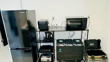 A compact kitchenette with a Hisense refrigerator, a microwave, a coffee maker, and a small oven.