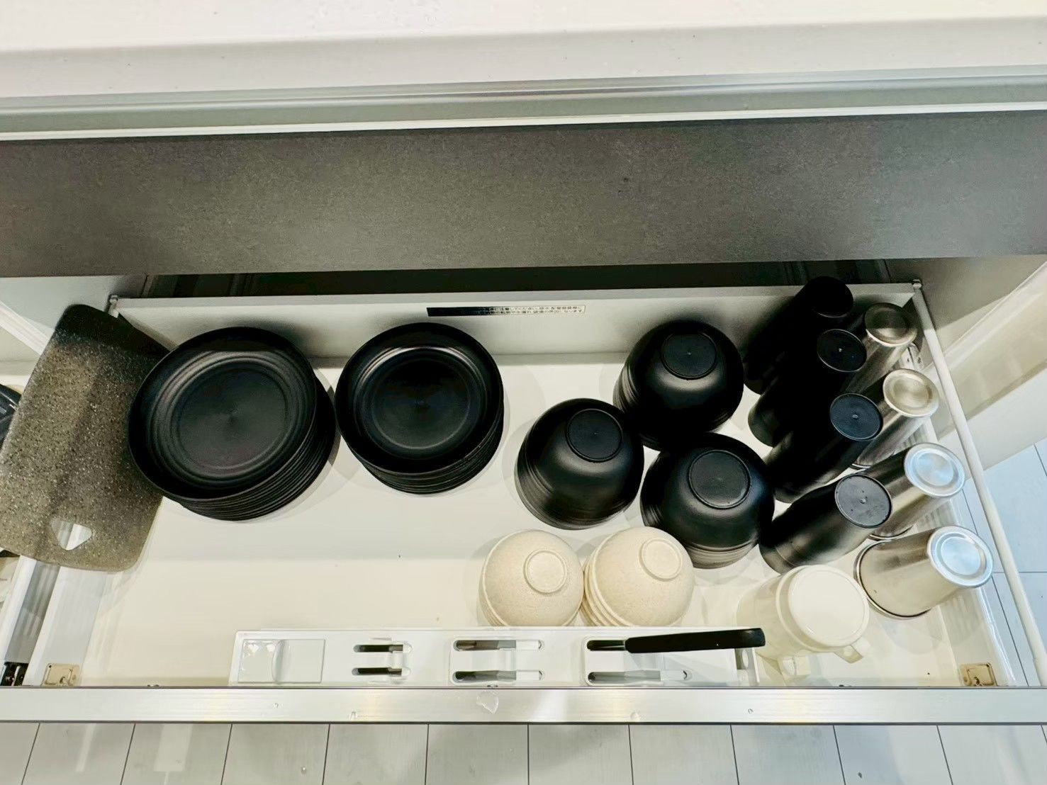 A kitchen drawer with various utensils and cookware.