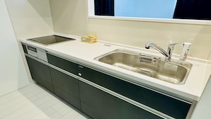A modern kitchen with a double sink, a dishwasher, and a window above the sink.