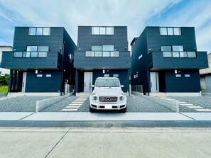 A modern building with a white car parked in front.