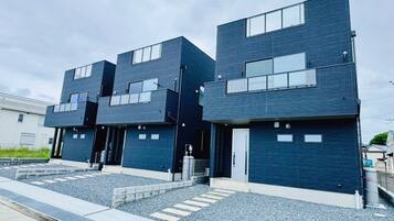 Un immeuble moderne à plusieurs étages, doté d’un toit plat et de grandes fenêtres.