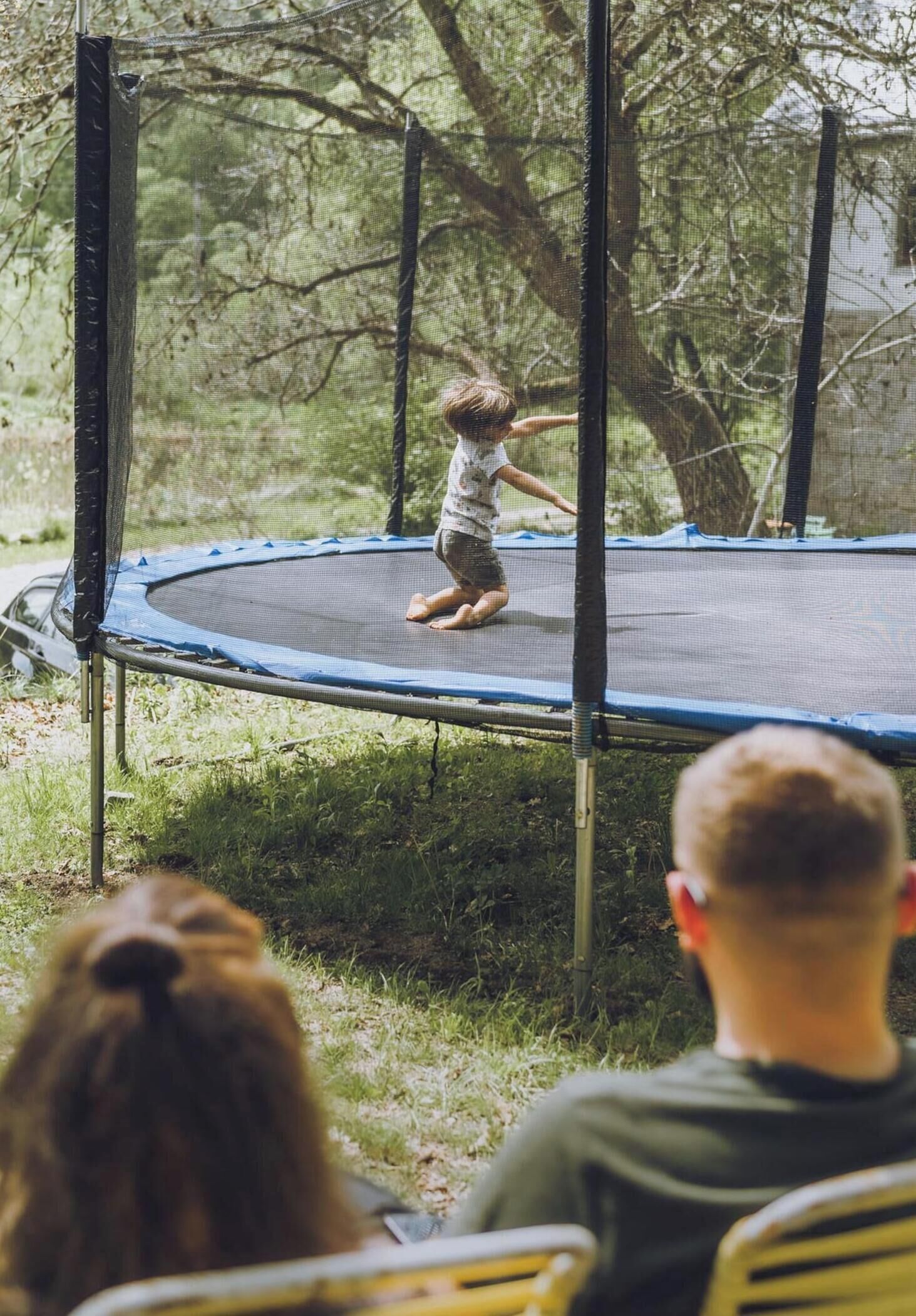 Un trampolín en un entorno al aire libre con árboles de fondo.