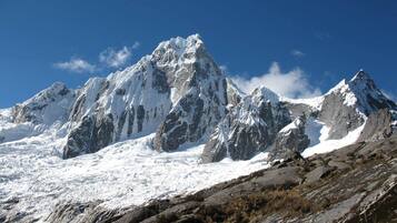 Ein verschneites Gebirge mit schroffen Gipfeln und blauem Himmel.