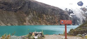 A signpost with a mountain and a lake in the background.