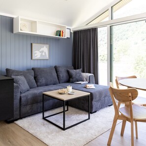 Ein modernes Wohnzimmer mit einer Couch, einem Couchtisch und einem Essbereich mit Stühlen.