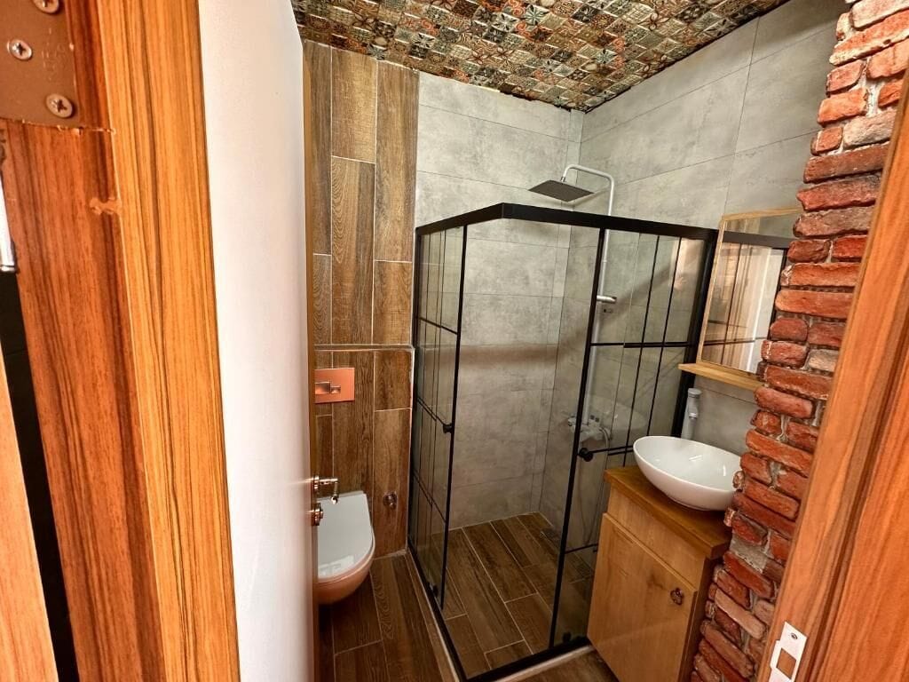 Ein Badezimmer mit Duschkabine, Toilette und Waschbecken.