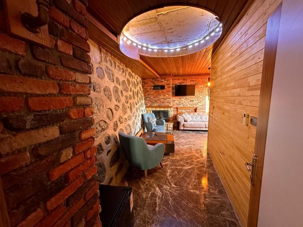 Un interior acogedor con pared de ladrillo, techo de madera y suelo de mármol.