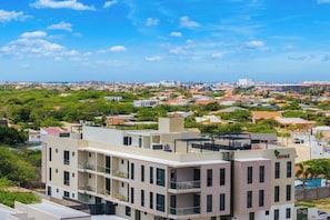 Un hôtel à plusieurs étages doté de balcons, offrant une vue dégagée sur le paysage urbain environnant et arborant un logo bien visible sur la façade.