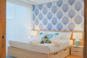 Ein Schlafzimmer mit einem großen Bett, zwei Nachttischen und einer Wand mit Muster.