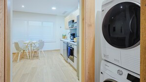 Una cucina moderna con forno integrato, microonde e una lavatrice Samsung.
