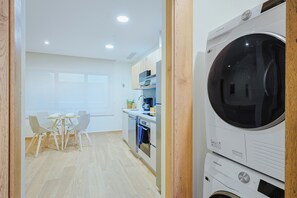 Eine moderne Küche mit Einbauofen, Mikrowelle und einer Samsung Waschmaschine.