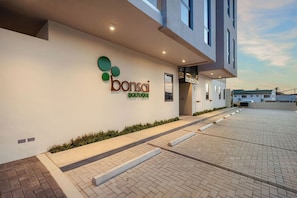 Un bâtiment moderne dont la façade extérieure porte une enseigne indiquant « boutique de bonsaïs ».