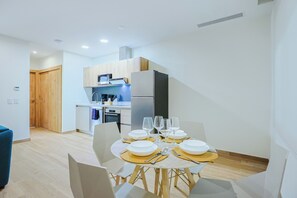 A modern kitchen with white cabinets, a microwave, and a refrigerator. - Bonsai 1BR Suite-Breezy Palm 208 (Noord)