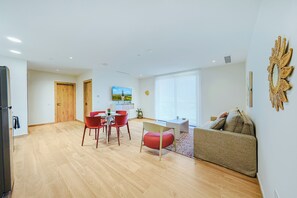 A modern living space with a dining area, a sofa, and a television. - Bonsai 1BR Suite- Yutori 306 (Noord)