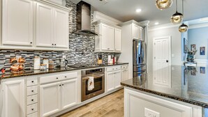 A modern kitchen with white cabinetry, a stainless steel range, and a patterned backsplash. - Sun, Fun & Soak: Stunning Myrtle Beach Escape! (Myrtle Beach)