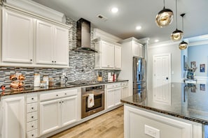 A modern kitchen with white cabinetry, a stainless steel range, and a patterned backsplash. - Sun, Fun & Soak: Stunning Myrtle Beach Escape! (Myrtle Beach)