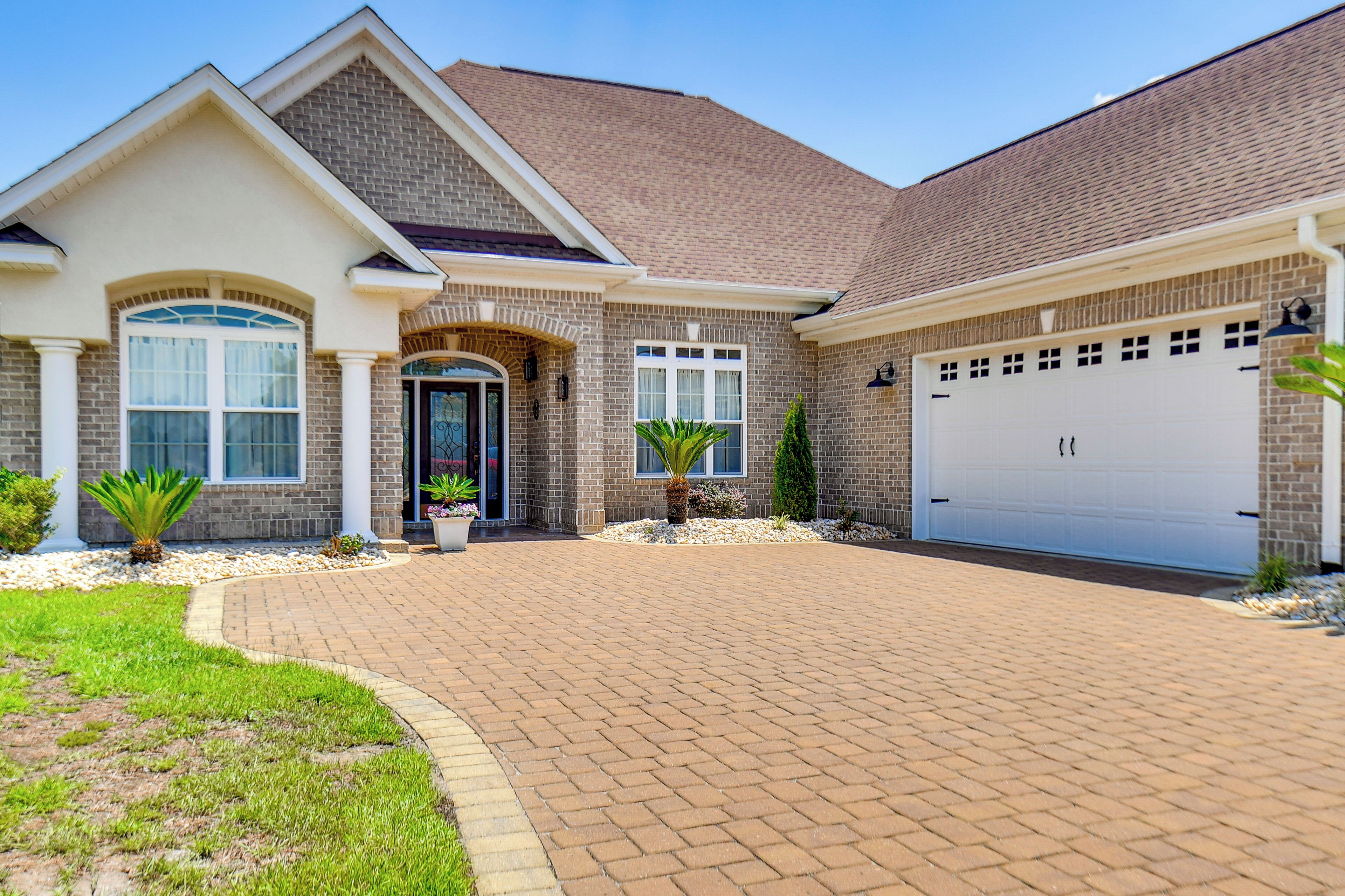 A two-story house with a brick facade, a front entrance, and a garage.