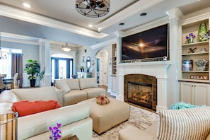 A spacious living room with a fireplace, a large flat-screen TV, and a comfortable seating area. - Sun, Fun & Soak: Stunning Myrtle Beach Escape! (Myrtle Beach)