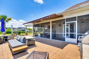 An outdoor patio area with a covered seating area, a grill, and a pool. - Sun, Fun & Soak: Stunning Myrtle Beach Escape! (Myrtle Beach)