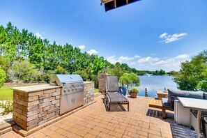 A patio with a grill, seating, and a view of a lake. - Sun, Fun & Soak: Stunning Myrtle Beach Escape! (Myrtle Beach)