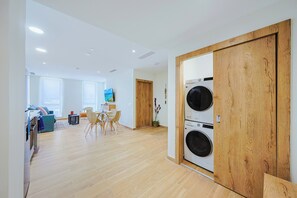 A modern apartment with a dining area, a living room, and a laundry room with two washing machines. - Bonsai 2BR Retreat-Flow 201 (Noord)