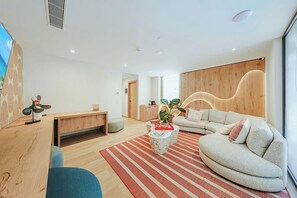 Un salon moderne avec un canapé, une table basse et un bureau.