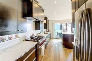 A modern kitchen with stainless steel appliances, a marble countertop, and a view of the outdoors. - Stunning Lake & Mtn Views! Cb/incline Village Home (Incline Village)