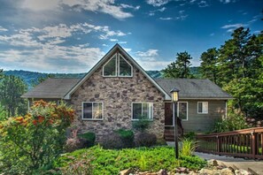 A stone house with a gabled roof, a front porch, and a wooden fence. - Amazing views, hot tub, foosball! (McGaheysville)