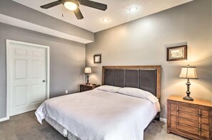 A bedroom with a bed, two bedside tables with lamps, a ceiling fan, and a door. - Amazing Views! Hot tub, Dog Friendy bonus Loft! (McGaheysville)