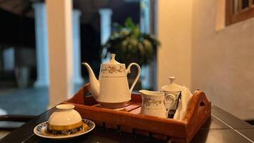 Una bandeja con una tetera, una taza y un platito sobre una mesa.