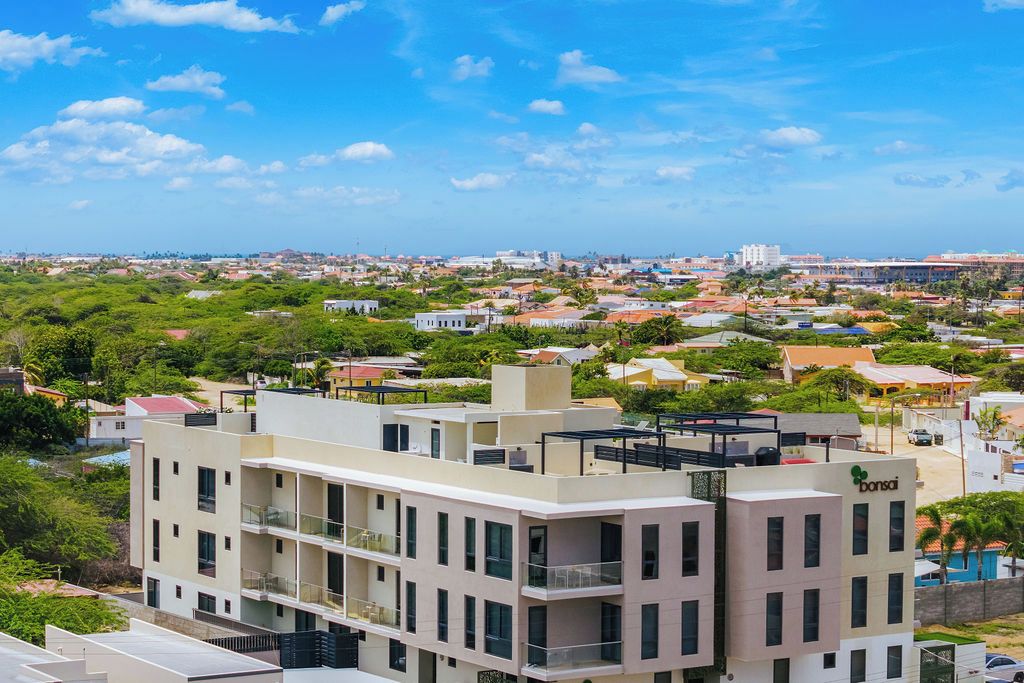 Un hôtel à plusieurs étages doté de balcons, offrant une vue dégagée sur le paysage urbain environnant et arborant un logo bien visible sur la façade.