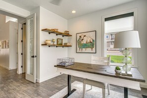 Une cuisine moderne avec une table en bois, des murs blancs et une fenêtre donnant sur un beau paysage.