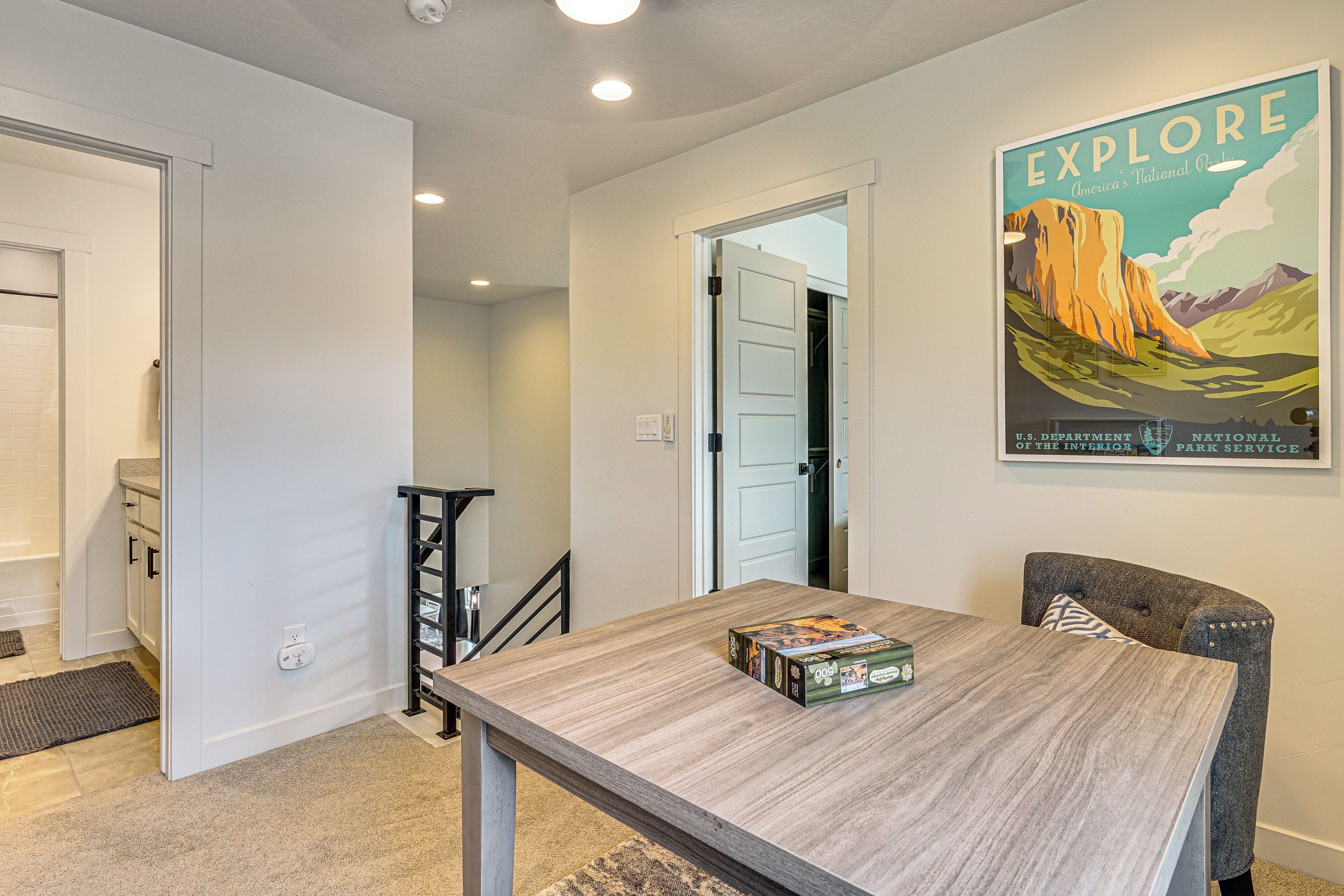A dining area with a wooden table, chairs, and a poster on the wall.
