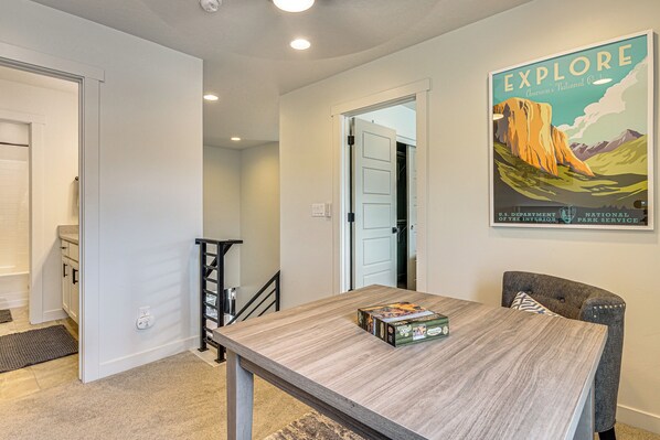 A dining area with a wooden table, chairs, and a poster on the wall.