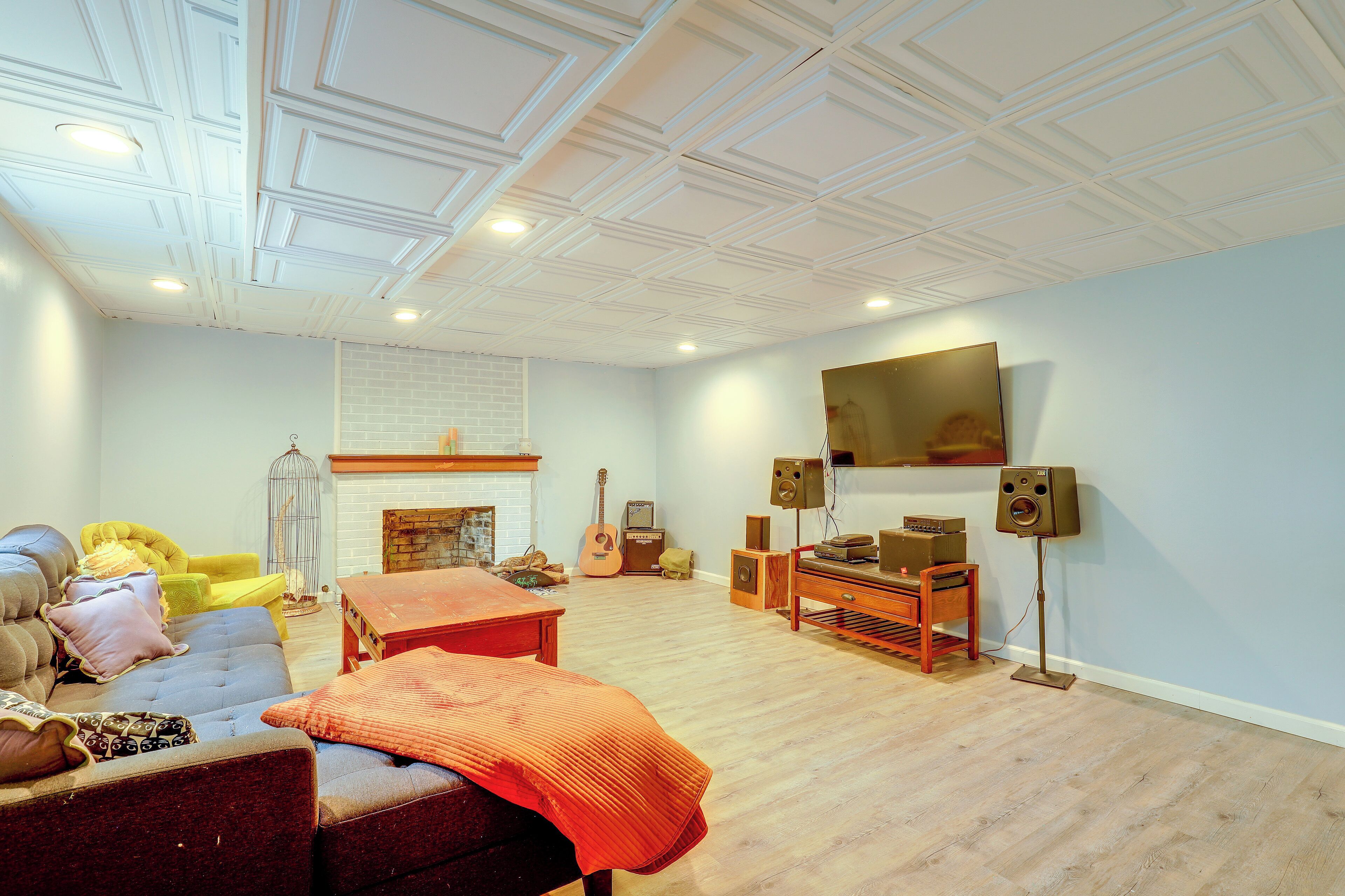 A living room with a fireplace, a television mounted on the wall, and a wooden coffee table.
