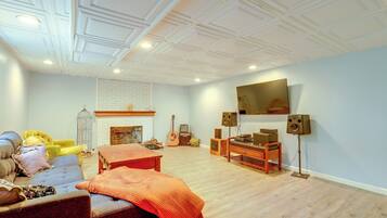 A living room with a fireplace, a television mounted on the wall, and a wooden coffee table.