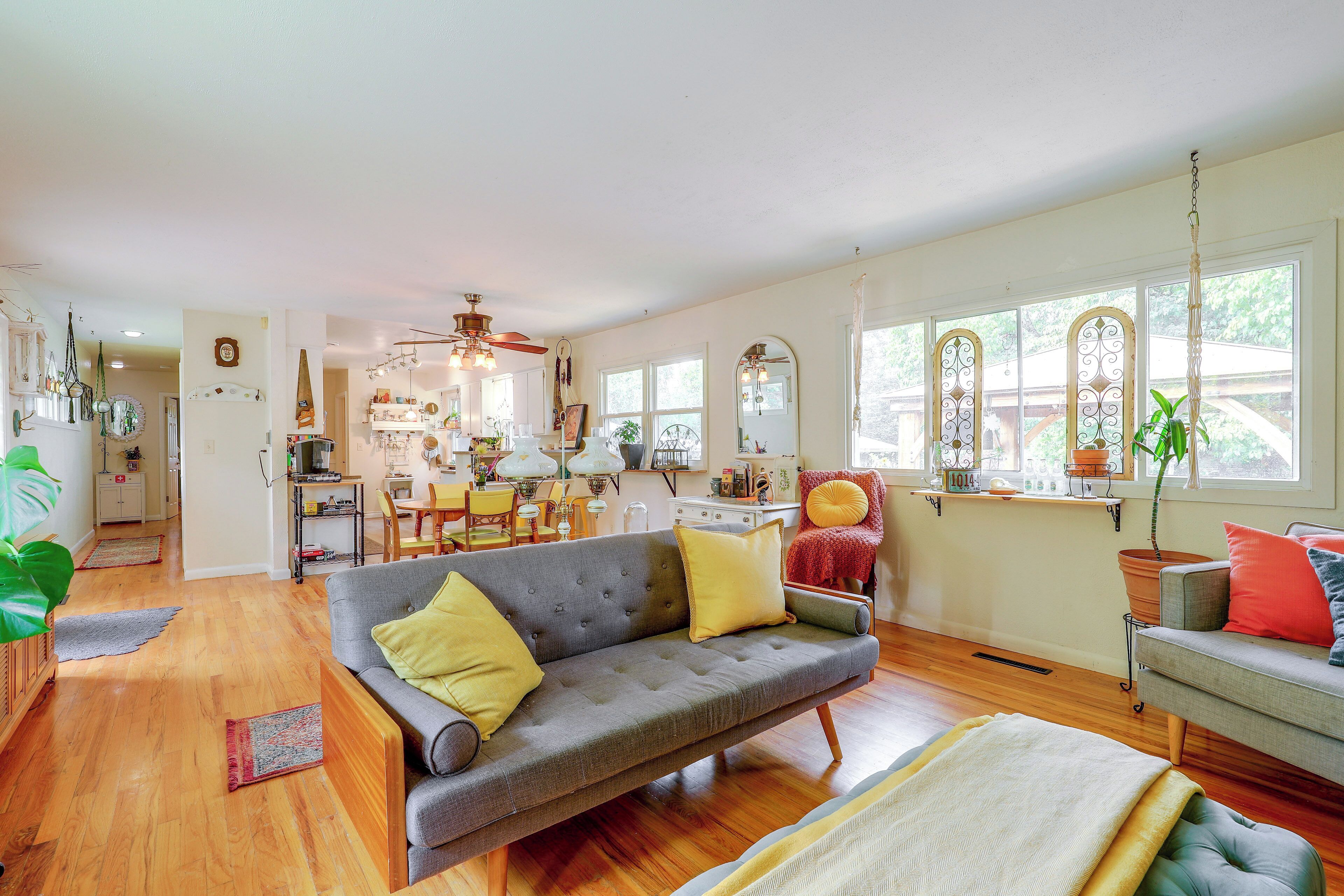 A spacious living area with a sofa, a dining table, and a kitchen in the background.