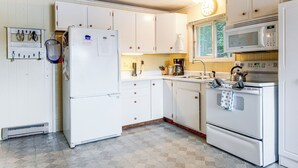 A kitchen with white cabinets, a refrigerator, a microwave, and a stove. - Lakefront Family Home w/ Docks in Barnstead! (Center Barnstead)