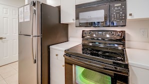 A kitchen with stainless steel appliances, including a refrigerator, microwave, and oven. - Pawleys Island Golf + Beach Getaway w/ Pool Access (Pawleys Island)