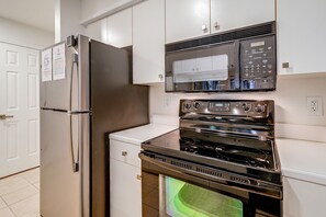 A kitchen with stainless steel appliances, including a refrigerator, microwave, and oven. - Pawleys Island Golf + Beach Getaway w/ Pool Access (Pawleys Island)