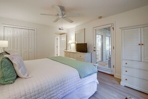A bedroom with a bed, a ceiling fan, a dresser, a television, and a closet. - Pawleys Island Golf + Beach Getaway w/ Pool Access (Pawleys Island)