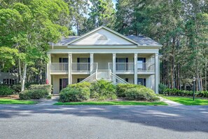 A two-story house with a front porch, a driveway, and a well-maintained lawn. - Pawleys Island Golf + Beach Getaway w/ Pool Access (Pawleys Island)