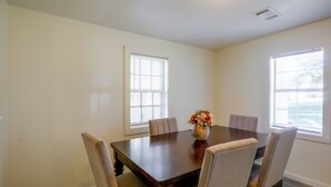 A conference room with a wooden table, six chairs, and a vase with flowers. - Tailgate Ready! 3 Mi to Ole Miss & the Square (Oxford)