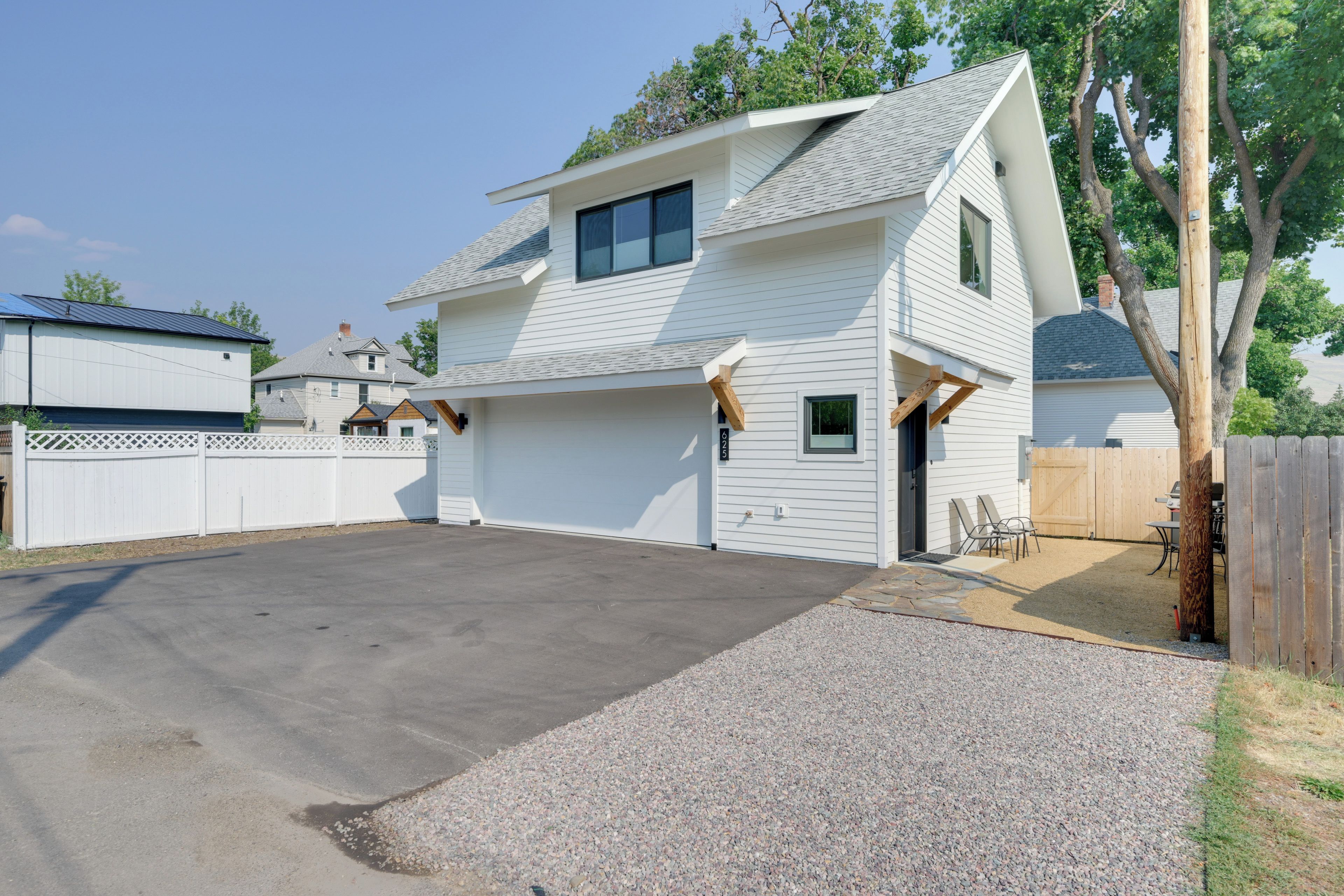A two-story house with a covered patio and a driveway.