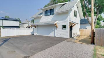 A two-story house with a covered patio and a driveway.